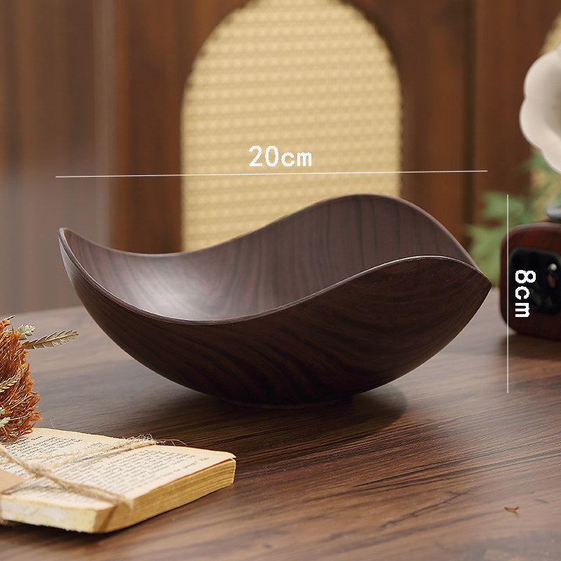 Dark brown wooden bowl with a wavy, organic shape, shown on a wooden table with overlaid dimension lines indicating 20cm width and 8cm depth.