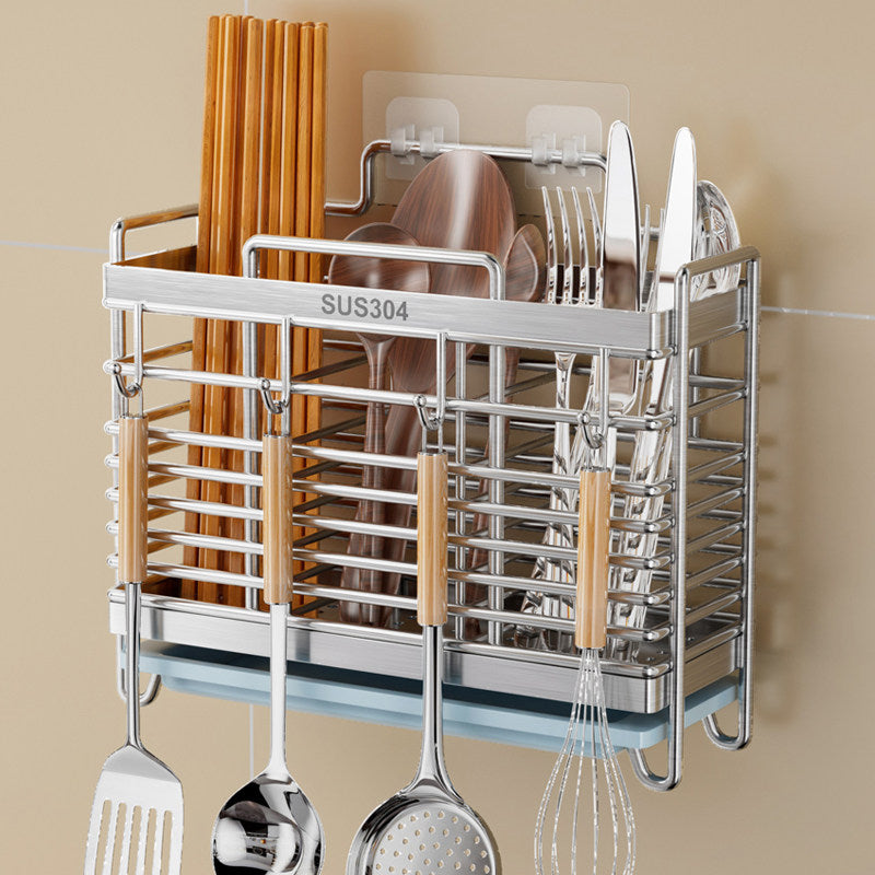 A stainless steel wall-mounted dish rack with wooden-handled utensils and chopsticks, shown against a beige wall.