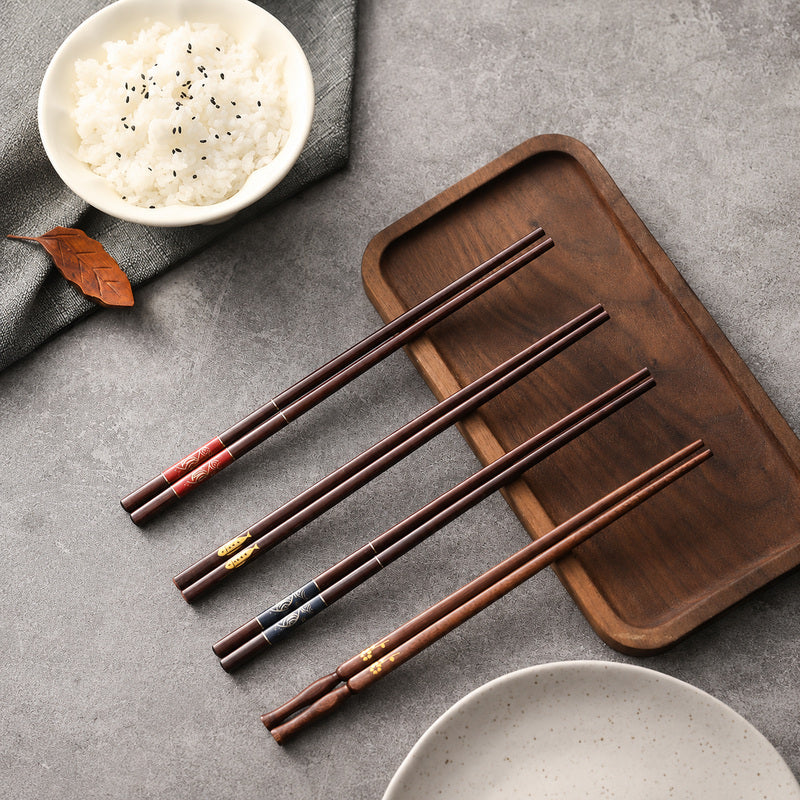 Set of four pairs of reusable wooden chopsticks with fish and floral designs