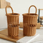Two small woven wicker baskets with loop handles, shown side by side on a wooden board in a kitchen setting.