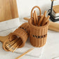 Two woven wicker chopstick holders on a white marble board, filled with wooden chopsticks, in a bright kitchen setting.