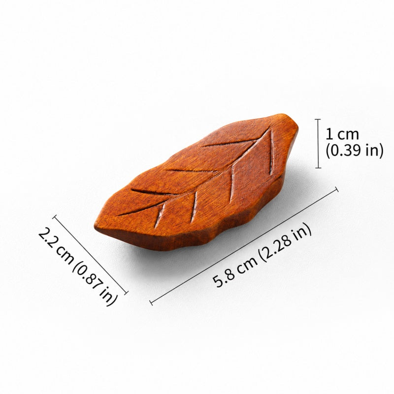 A small leaf-shaped wooden object on a white background with measurement labels showing 2.2 cm length, 5.